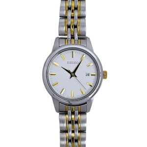 May include: A silver and gold-toned Seiko wristwatch with a white face. The watch features gold-colored hands and hour markers, a date display at the 3 o'clock position, and a two-tone metal band. The watch is a classic design.