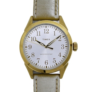 Könnte beinhalten: Eine goldfarbene Uhr mit weißem Zifferblatt und schwarzen Zeigern. Die Uhr hat ein goldfarbenes Armband und trägt die Aufschrift "TIMEX" und "WATER RESISTANT" auf dem Zifferblatt.