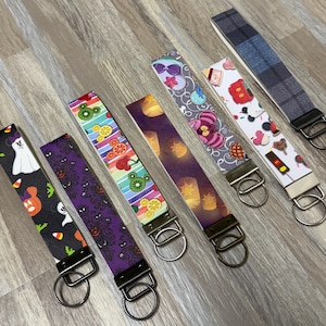 Puede incluir: Una colección de siete llaveros con varios diseños. Los diseños incluyen un fantasma, Mickey Mouse, una casa embrujada, frutas, linternas, Alicia en el país de las maravillas y cuadros escoceses. Cada llavero tiene un anillo y un cierre de metal.