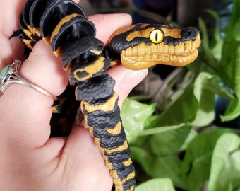 Tapis articulé en python de la jungle avec yeux en verre