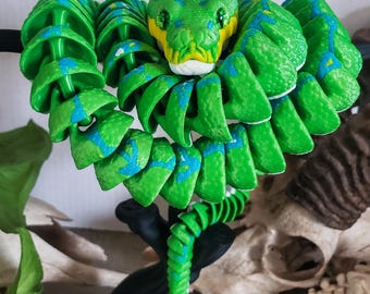 Gelede groene boompython met glazen ogen en boomstandaard