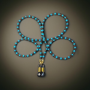 Op de afbeelding: Een glazenketting met kralen in een ontwerp met vier lussen. De ketting heeft kleine, donkerbruine kralen afgewisseld met heldere turquoise kralen. De ketting eindigt met goudkleurige metalen spoelen en zwarte rubberen lussen.