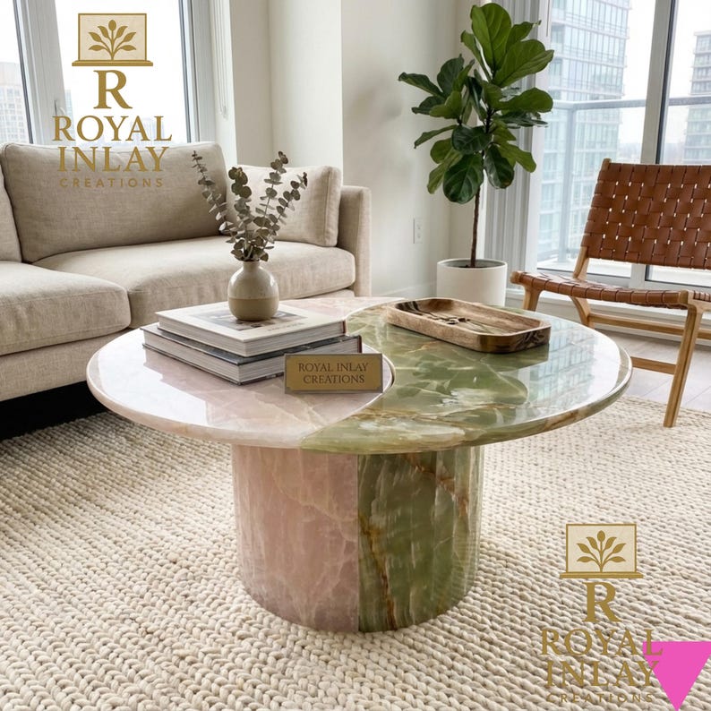 May include: A round coffee table with a pink and green marble top and a cylindrical base. The table is divided into two sections, with the pink section on the left and the green section on the right. The table is in a living room setting.