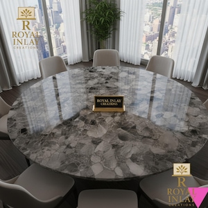 以下が含まれることがあります： グレーと白の模様の表面を持つ、大きな丸いダイニングテーブル。テーブルの周りには、いくつかのクリーム色の椅子があります。テーブルには「ROYAL INLAY CREATIONS」と書かれたサインがあります。部屋には、街の景色を望む大きな窓があります。