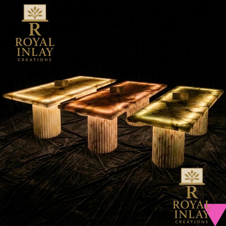 May include: Three illuminated rectangular tables with a glowing surface and cylindrical, ribbed bases. The tables have a warm, inviting glow, with colors ranging from amber to green. The text "ROYAL INLAY CREATIONS" is displayed.