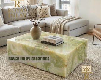 Puede incluir: Una mesa de centro rectangular de ónix verde con vetas blancas y marrones. La mesa está en un salón, con un sofá gris, una alfombra beige y un jarrón decorativo. El texto "ROYAL INLAY CREATIONS" se muestra en la mesa.