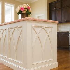 Puede incluir: Isla de cocina color crema con encimera rosa y paneles decorativos. La isla presenta un arreglo floral y est&aacute; ubicada en una cocina con gabinetes de madera oscura y electrodom&eacute;sticos de acero inoxidable. El logotipo de Royal Inlay Creations es visible.