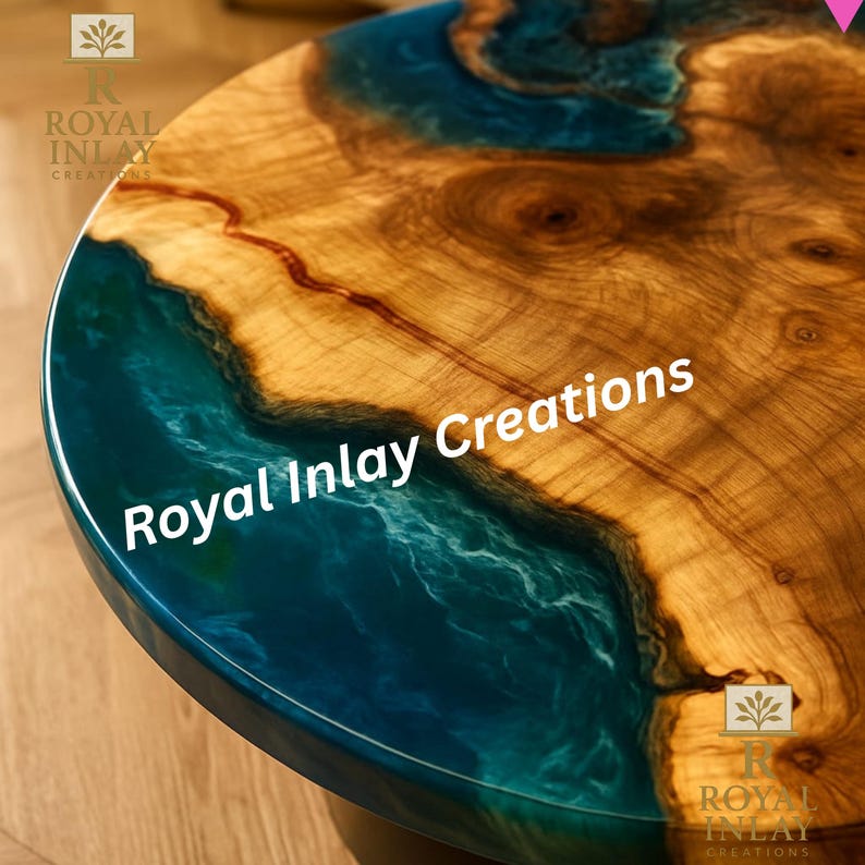 May include: Round wooden table with a unique design. The table features a natural wood grain pattern with a deep blue epoxy resin inlay. The text "Royal Inlay Creations" is visible on the surface.