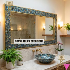 May include: A rectangular mirror with a mosaic-style frame in shades of blue, green, and gold. The mirror is mounted above a marble countertop with a matching mosaic sink. The text "ROYAL INLAY CREATIONS" is displayed on the mirror.