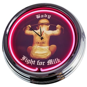 Könnte beinhalten: Eine rosa Neon-Uhr mit einem verchromten Rahmen. Das Zifferblatt der Uhr zeigt ein Cartoon-Baby mit Tattoos und den Text "Baby Fight for Milk".