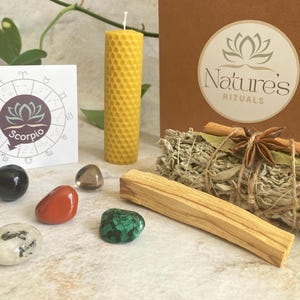 May include: A zodiac kit for Scorpio featuring a beeswax candle, sage smudge stick, palo santo stick, and crystals. The kit also includes a card with the zodiac symbol and the word "Scorpio".