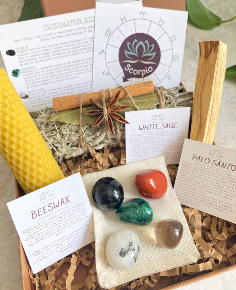 May include: A gift box set for Scorpio zodiac sign with crystals, a beeswax candle, white sage, palo santo, and a cinnamon stick. The box includes a card with the Scorpio zodiac symbol and information about the crystals.