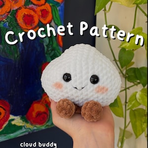 Può includere: Un peluche a forma di nuvola lavorato all'uncinetto in bianco con occhi di sicurezza neri, guance rosa e piccoli piedi marroni. Il testo recita Crochet Pattern e cloud buddy pdf download. Il peluche ha una superficie in filato testurizzato.