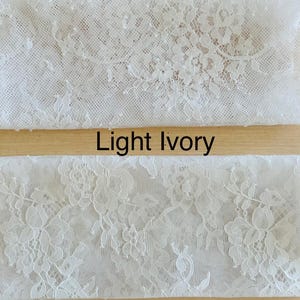 Peut inclure: Deux &eacute;chantillons de tissu en dentelle, un blanc et un ivoire clair. La dentelle a un motif floral. Le texte "Blanc" est au-dessus de l'&eacute;chantillon blanc et le texte "Ivoire clair" est au-dessus de l'&eacute;chantillon ivoire.