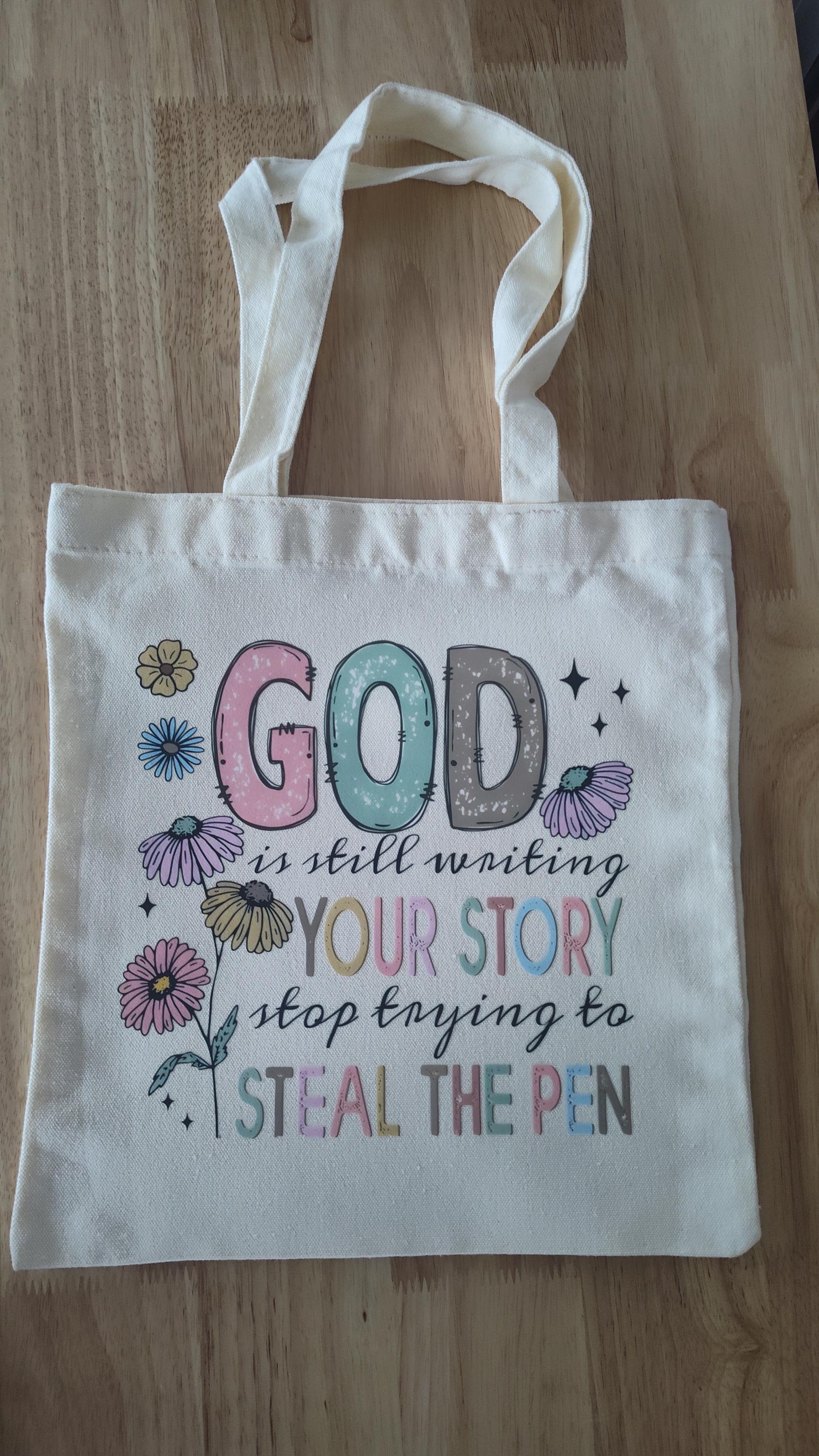 God is still writing your story canvas tote bag