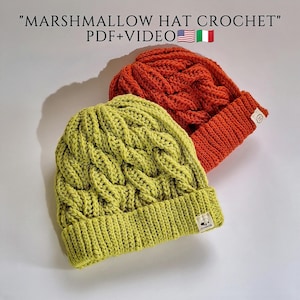 Könnte beinhalten: Zwei handgefertigte Häkelmützen, eine in leuchtendem Grün und die andere in warmem Orange. Beide Mützen haben ein Zopfmuster und einen umgeschlagenen Rand. Der Text "MARSHMALLOW HAT CROCHET" ist oben zu sehen.
