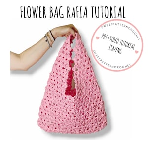 Può includere: Una borsa a uncinetto rosa con un motivo floreale. La borsa è tenuta da una mano. Il testo "PDF+VIDEO TUTORIAL ITA/ENG" è in un cerchio rosa con sfondo bianco.