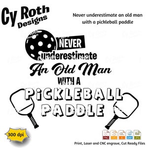 May include: Black and white graphic design with the text "Never underestimate an old man with a pickleball paddle". The graphic includes a pickleball and two pickleball paddles.