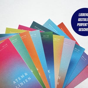 May include: A fan of colorful cards with gradient designs, featuring text in white. The cards are arranged in a semi-circle, with a dark blue circle in the upper right corner containing white text. The cards have the text "ATEM & LINIEN".