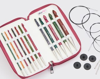 May include: A crochet hook set in a zippered case. The case is open, revealing a variety of colorful crochet hooks with wooden handles and metal tips. The set includes circular knitting needles, black stoppers, and the Knit Pro logo.