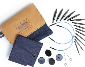 Puede incluir: Un juego de agujas de tejer con temática denim con un estuche marrón y denim. El estuche está abierto, revelando agujas de tejer negras, un cable azul y accesorios. El estuche lleva la etiqueta "DENIM SPECIAL COLLECTORS EDITION".