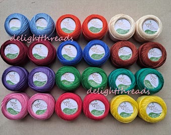 May include: A collection of colorful Anchor Pearl Cotton thread balls in various shades, including blue, red, green, and yellow. Each ball is labeled with product information. The word "delightthreads" is visible.