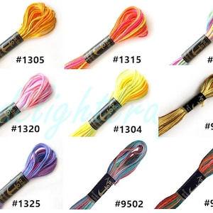 May include: Nine skeins of Anchor embroidery floss in various colors. The skeins are labeled with numbers, including #1305, #1315, #1335, #1320, #1304, #9501, #1325, #9502, and #9503. The colors range from yellow and orange to pink, blue, and green.