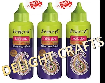 Puede incluir: Tres botellas de pegamento para tela Fevicryl con tapas y etiquetas verdes. Las etiquetas presentan el texto "fabric glue" y "Premium" en inglés y otros idiomas. Las botellas tienen una base morada con un diseño decorativo.