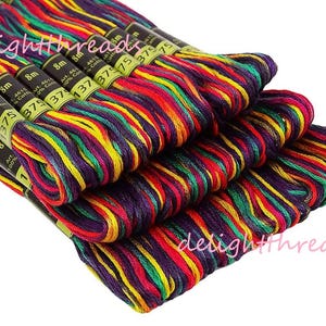May include: Close-up of several skeins of colorful embroidery floss. The floss is a mix of vibrant colors including red, yellow, green, and purple. Each skein is labeled with the brand name and color number. The image also includes the text "delightthreads".