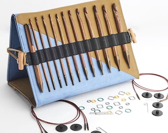May include: A crochet hook set with wooden hooks and a blue and tan case. The set includes various sizes of hooks, stitch markers, and other accessories. The case is secured with a wooden toggle closure.