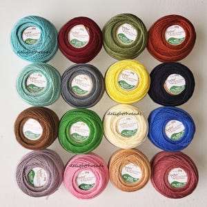 May include: A collection of colorful Anchor crochet cotton thread balls, each labeled with "20g" and "Anchor." The assortment includes shades of teal, burgundy, olive green, orange, mint, gray, yellow, black, brown, green, cream, blue, lavender, pink, and peach.