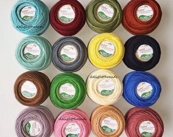 May include: A collection of colorful Anchor crochet cotton thread balls, each labeled with "20g" and "Anchor." The assortment includes shades of teal, burgundy, olive green, orange, mint, gray, yellow, black, brown, green, cream, blue, lavender, pink, and peach.