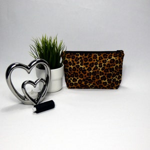 make up bag with a black zip with leopard print design on the fabric.