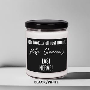 May include: A white candle with a black label that reads "Oh look...y'all just burnt Mr. Garcia's LAST NERVE!" in white text. The candle is on a white surface and the text "BLACK/WHITE" is below the candle.