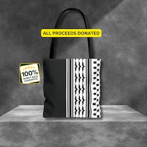 May include: Black and white tote bag with a geometric pattern. The bag has a black handle and the text "ALL PROCEEDS DONATED" is printed in yellow on a white background.