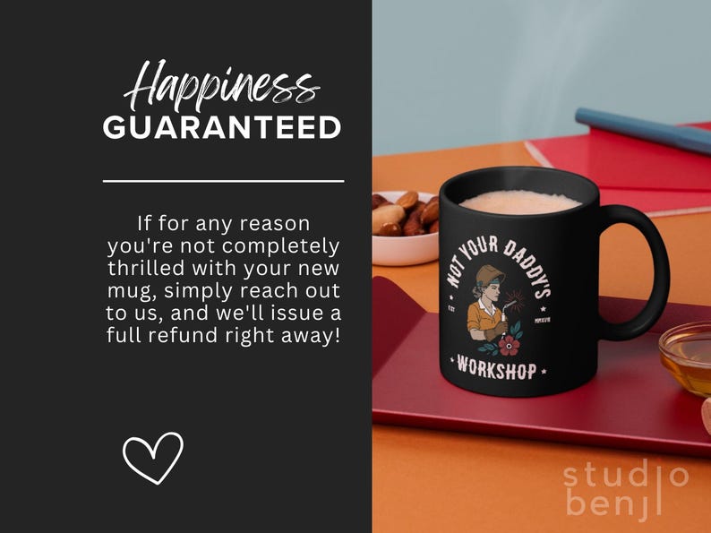 May include: Black ceramic mug with the text "NOT YOUR DADDY'S WORKSHOP" and an illustration of a woman welding. The mug is filled with a light-colored beverage and sits on a red tray. The image also includes text that says "Happiness GUARANTEED".