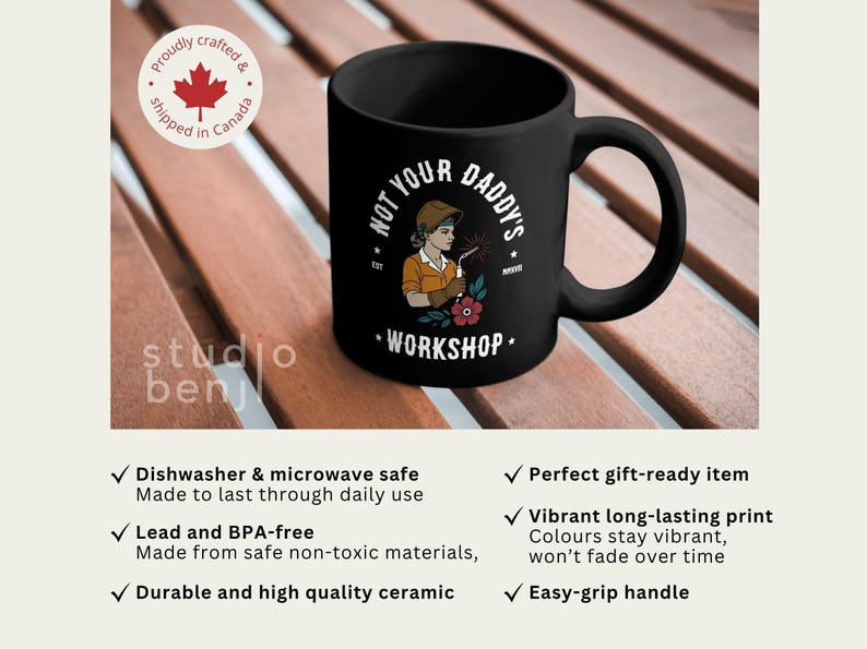 May include: Black ceramic mug with the text "NOT YOUR DADDY'S WORKSHOP" and an illustration of a female welder. The mug has a large handle and is on a wooden surface. The mug is dishwasher and microwave safe.