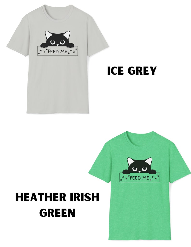 May include: Two t-shirts with a black cat peeking over a sign that says "Feed Me". The shirt on the left is light gray and the shirt on the right is a light green heather.