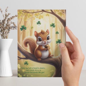 May include: A greeting card featuring a cartoon squirrel holding an acorn, perched on a tree branch. The card has a forest background with floating shamrocks. Text reads: "Some say luck is found in clovers, but I think it's in wonderful friends like you!"