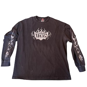 May include: Black long-sleeve shirt with the text "OCC Choppers" in a silver and white design on the front. The sleeves feature a silver flame design. The shirt has a crew neck and a tag at the back of the neck.