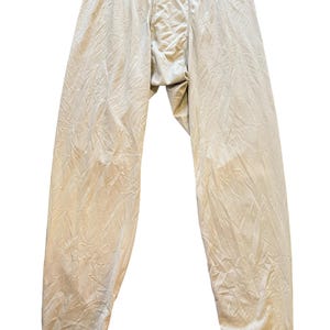 Könnte beinhalten: Ein Set aus drei Keramikbechern mit gesprenkelter, matter Oberfläche. Die Becher sind in den Farbtönen Creme, Hellgrau und Dunkelgrau gehalten. Jeder Becher hat ein schlichtes, minimalistisches Design und einen abgerundeten Griff.