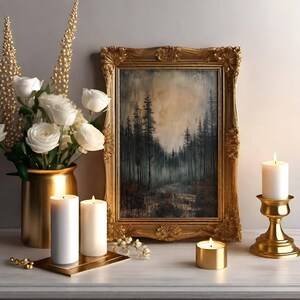 May include: A gold framed painting of a forest scene with white candles on a table. The candles are on a gold stand and a gold tray.