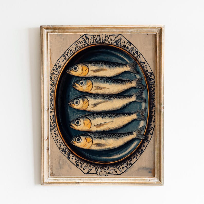 May include: A framed print of a painting depicting five sardines on a blue and white plate. The plate is decorated with a gold rim and a pattern of black and white lines.