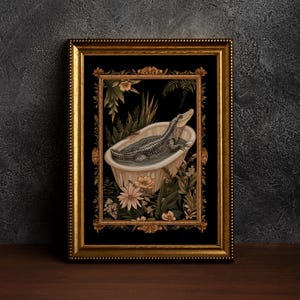 Op de afbeelding: Een ingelijste kunstdruk met een alligator die ontspant in een vintage badkuip. Het kunstwerk is omgeven door weelderig groen en bloemen, tegen een zwarte achtergrond. De gouden lijst met gedetailleerde rand voegt elegantie toe aan de sc&egrave;ne.