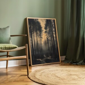 May include: A framed print of a forest scene with tall trees and a path leading into the woods. The print is in a wooden frame and is hanging on a green wall.