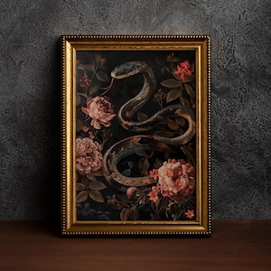 Può includere: Una stampa incorniciata di un serpente scuro avvolto attorno a fiori rosa e bianchi su uno sfondo nero. La cornice è dorata con un bordo perlato.