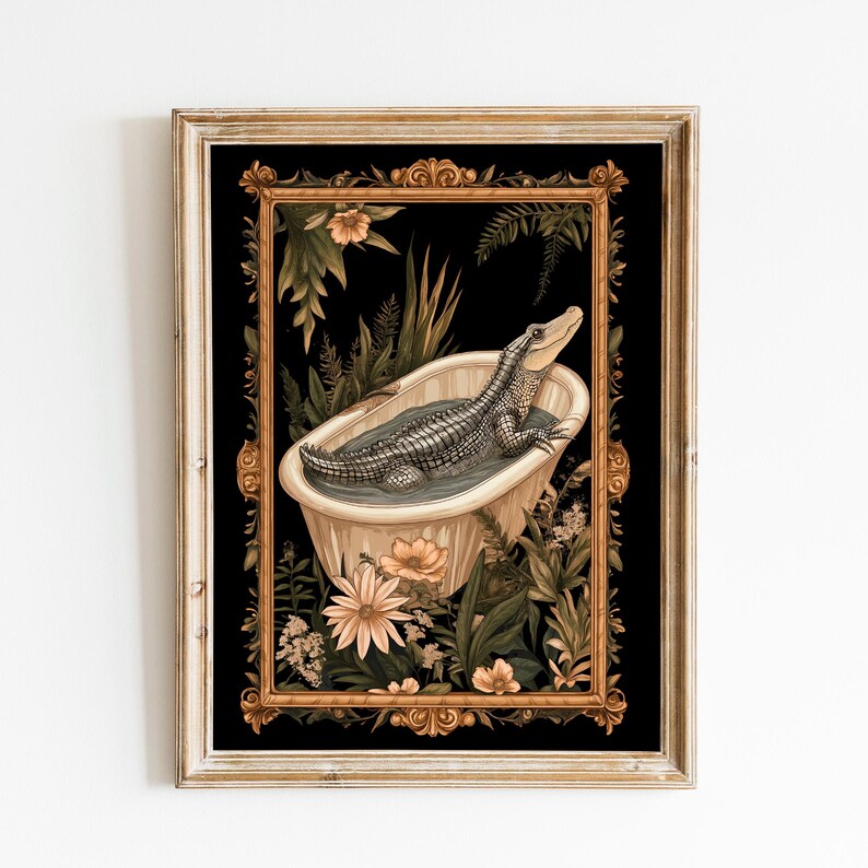 Op de afbeelding: Ingelijste kunstprint met een alligator die ontspant in een vintage badkuip. Het kunstwerk heeft een zwarte achtergrond met een gouden, sierlijke lijst en is omgeven door weelderig groen en bloemen. De alligator is gedetailleerd in grijstinten.
