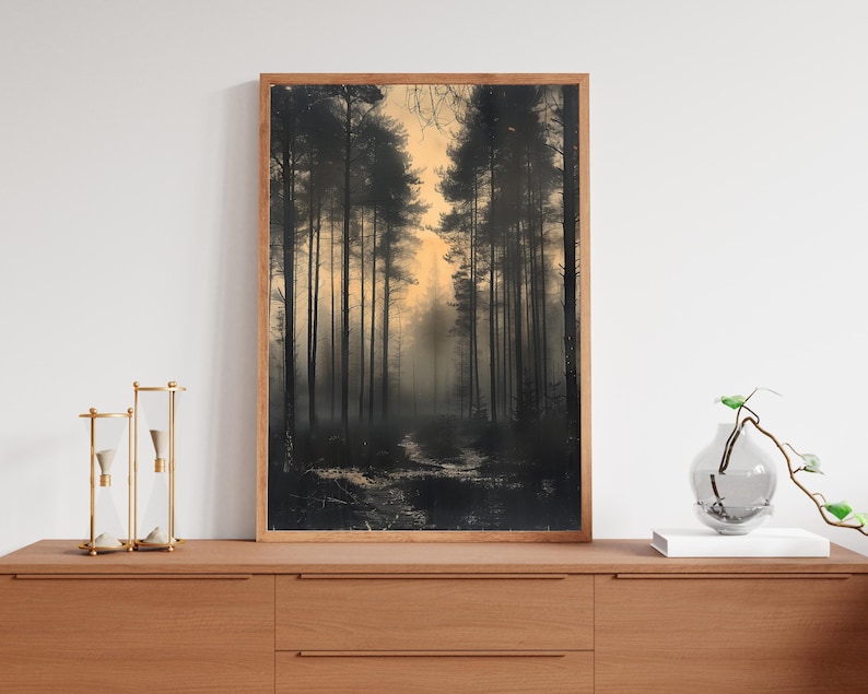 May include: A framed photograph of a misty forest scene with tall trees and a path leading into the distance. The trees are silhouetted against a pale orange sky.