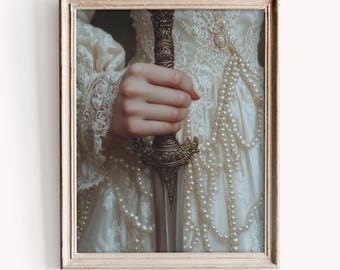 May include: A woman in a white lace dress holds a silver and gold dagger with a pearl necklace draped around her neck.