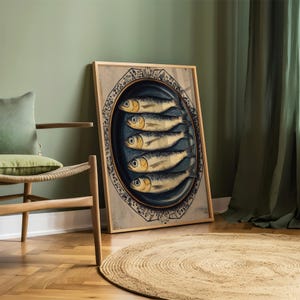 May include: A framed print of a vintage illustration of five sardines on a blue and white plate. The sardines are arranged in a row, with their tails pointing to the right. The plate is decorated with a floral pattern.